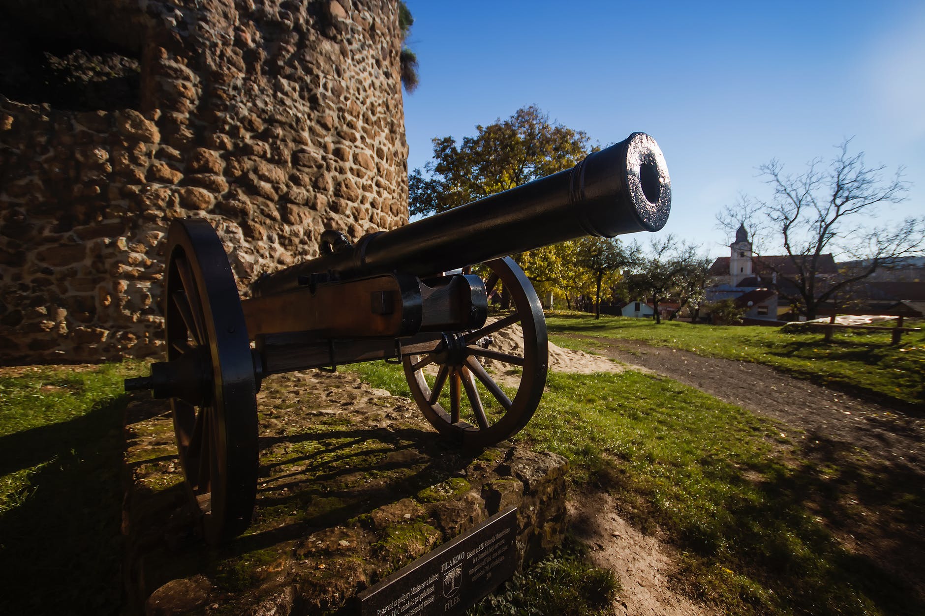 black cannon in front of the brick wall building