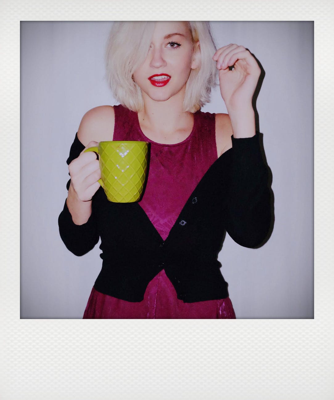 woman holding ceramic mug while smiling photo