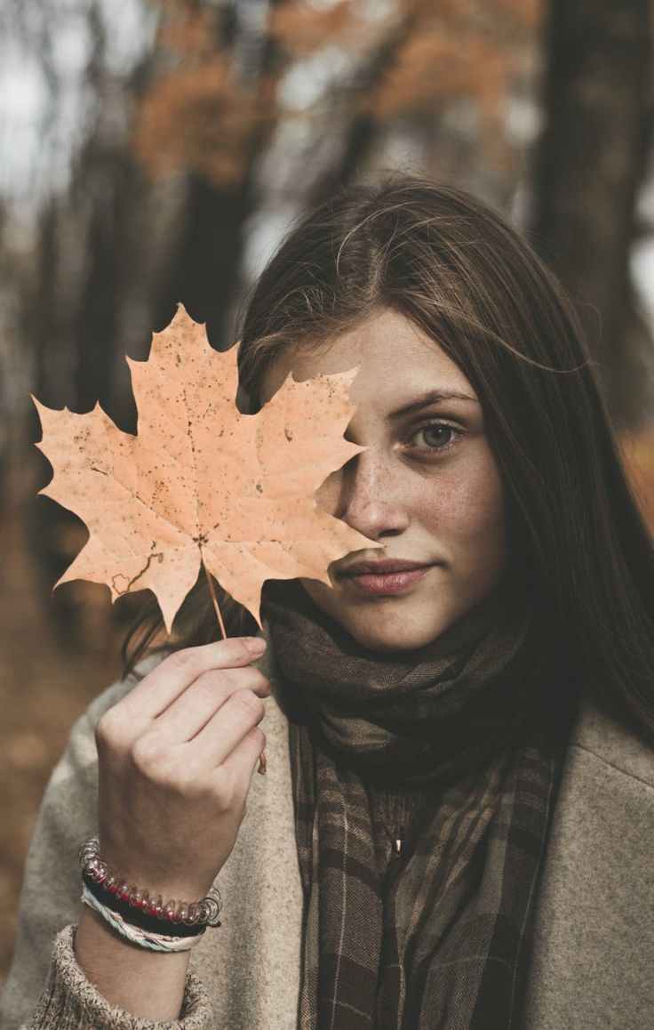 woman holding orange maple leaf